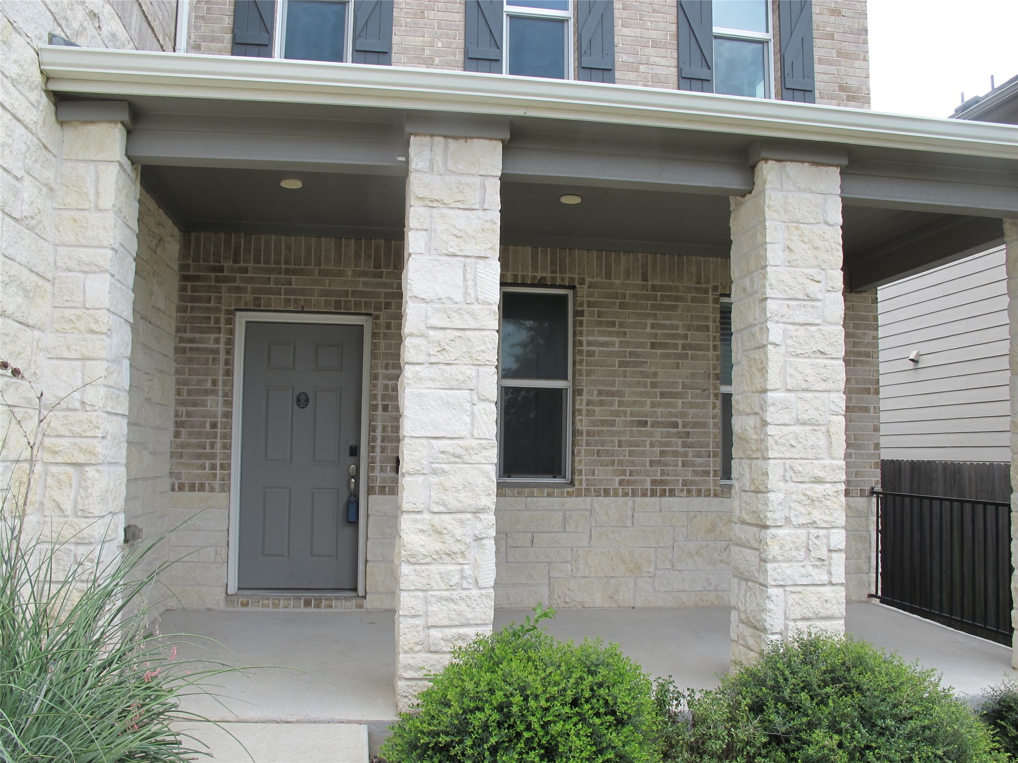 7820 Big Wind Way Austin, TX 78724 - Photo 3 of 37 Property entrance with stone siding, covered porch, and brick siding