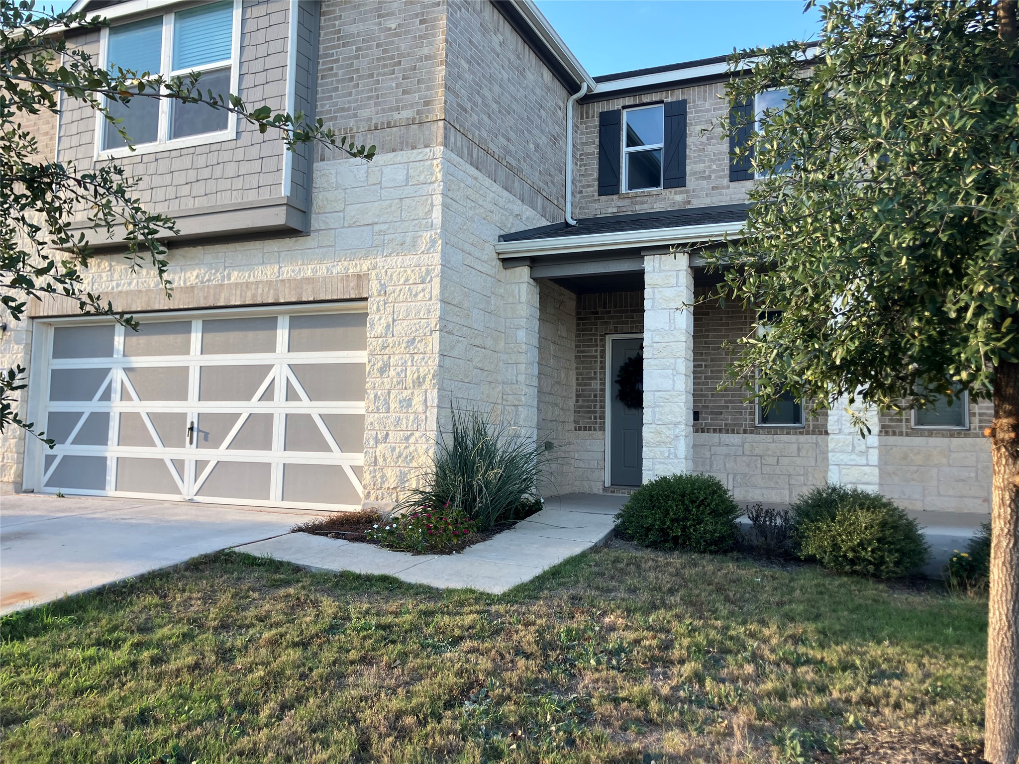 7820 Big Wind Way Austin, TX 78724 - Photo 4 of 37 View of front of house with a garage, driveway, stone siding, and a front yard