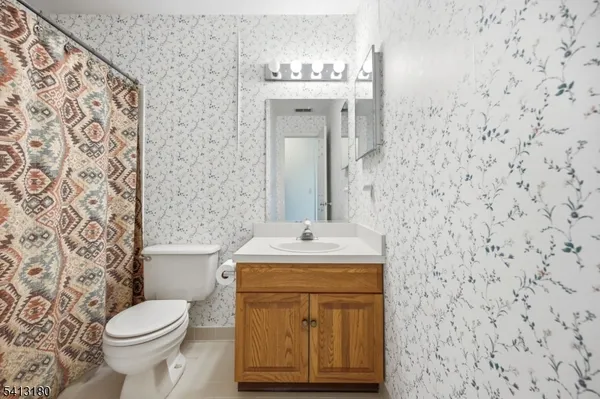 a bathroom with a granite countertop toilet sink and mirror