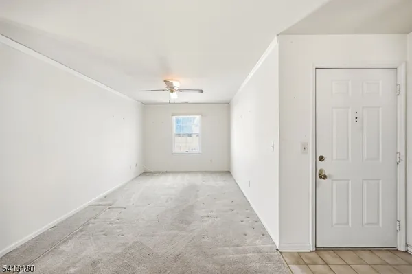 an empty room with windows and chandelier fan