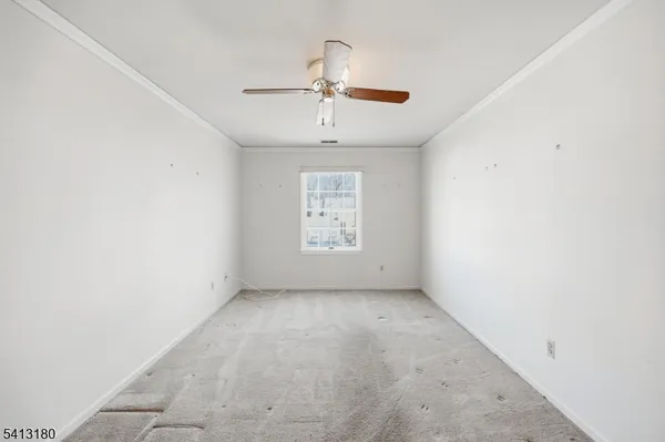 an empty room with a window and a ceiling fan