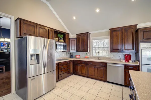 a kitchen with stainless steel appliances granite countertop a refrigerator sink and cabinets