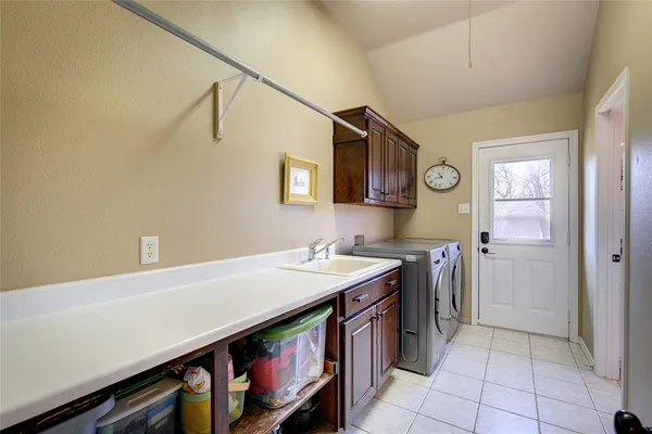 a utility room with stainless steel appliances cabinets and a window