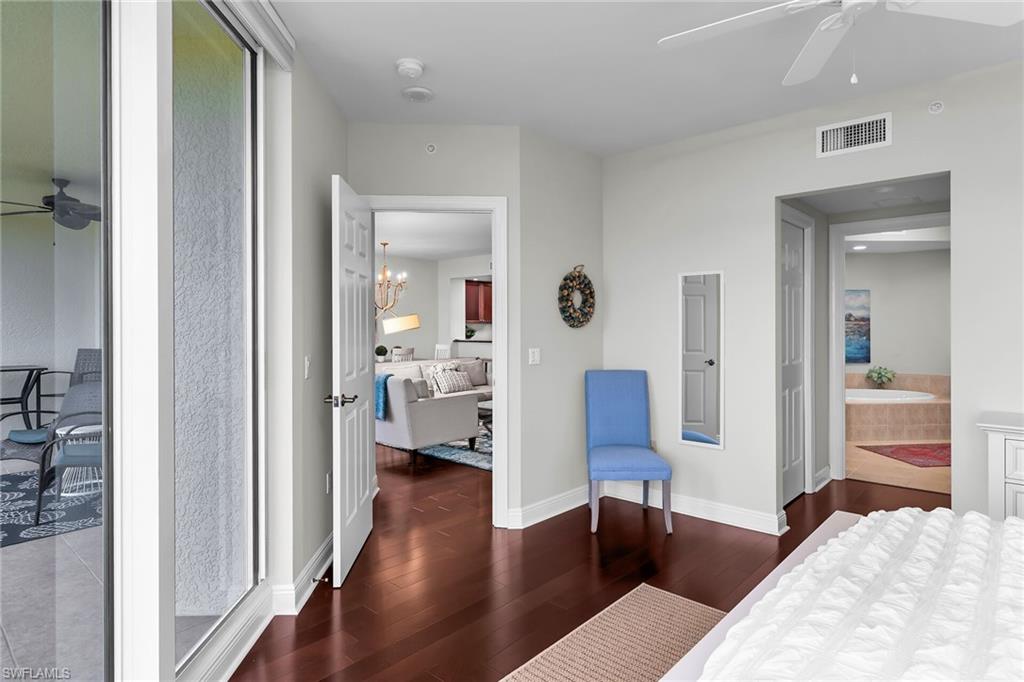 1065 Borghese Lane, Unit 1003 Naples, FL 34114 - Photo 15 of 35 a bedroom with furniture and a wooden floor