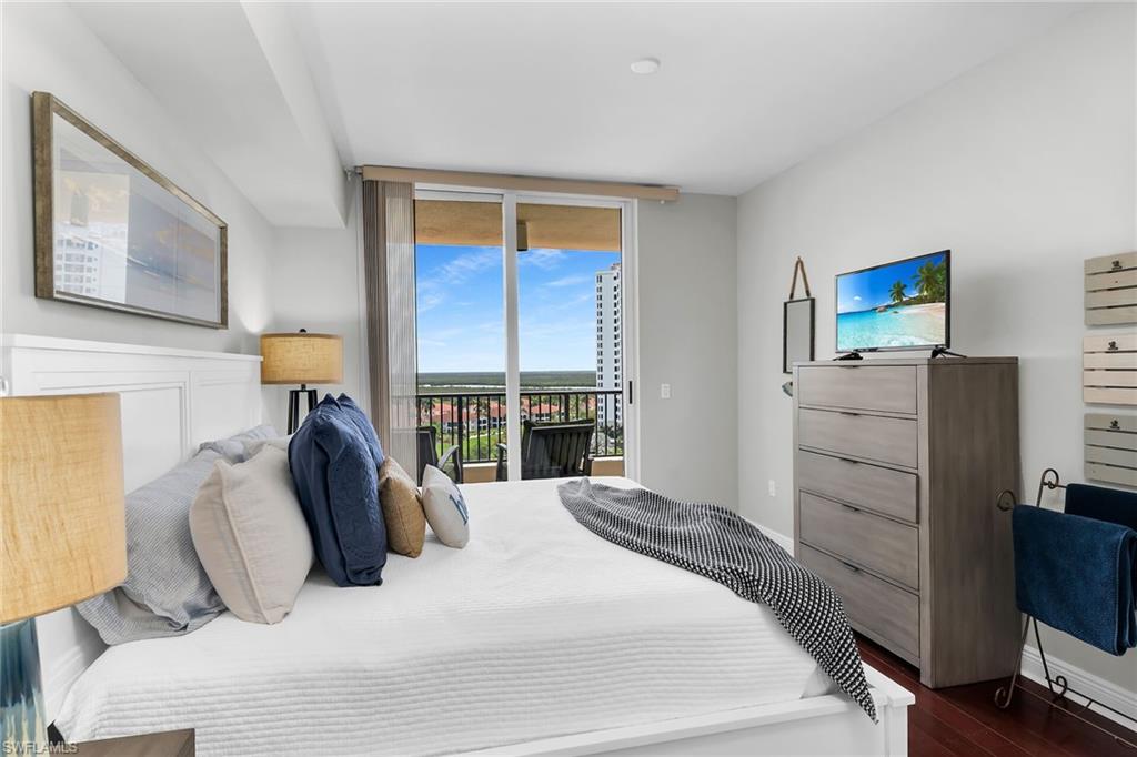 1065 Borghese Lane, Unit 1003 Naples, FL 34114 - Photo 25 of 35 a bedroom with a bed and wooden floor