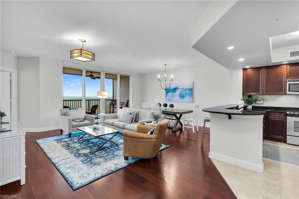 1065 Borghese Lane, Unit 1003 Naples, FL 34114 - Photo 4 of 35 a living room with furniture and a wooden floor