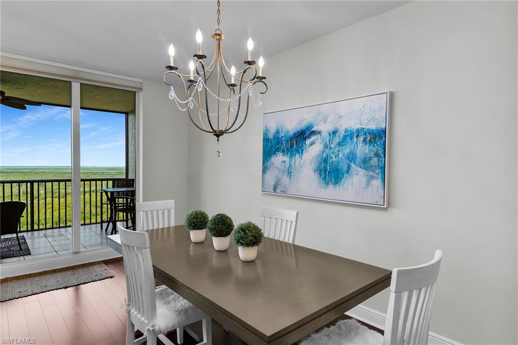 1065 Borghese Lane, Unit 1003 Naples, FL 34114 - Photo 8 of 35 a view of a dining room with furniture a chandelier and wooden floor