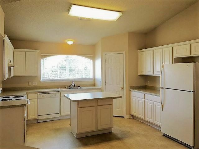134 Sandstone Trail Crestview, FL 32539 - Photo 5 of 18 a kitchen with a sink a stove a refrigerator and white cabinets