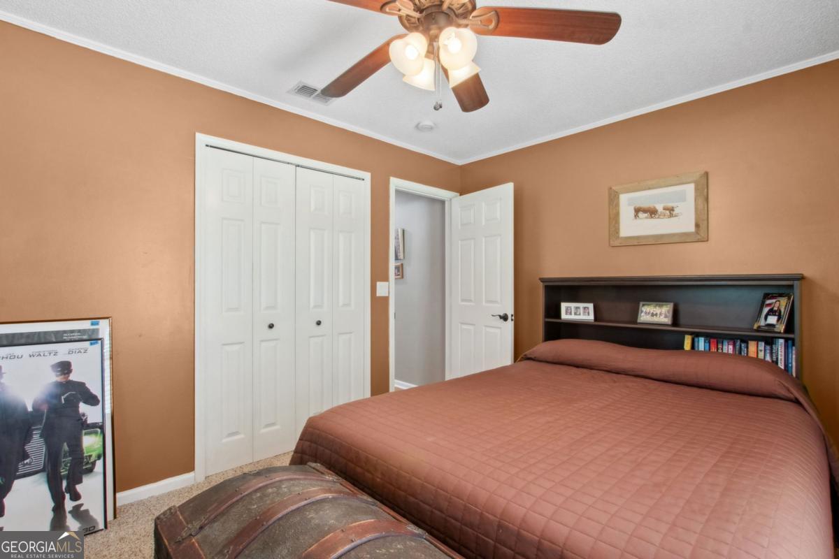 100 Longwood Road St. Marys, GA 31558 - Photo 26 of 39 a bedroom with a bed and a chandelier