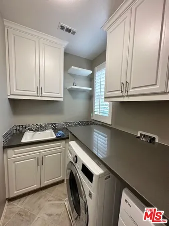 a kitchen with granite countertop a sink and cabinets