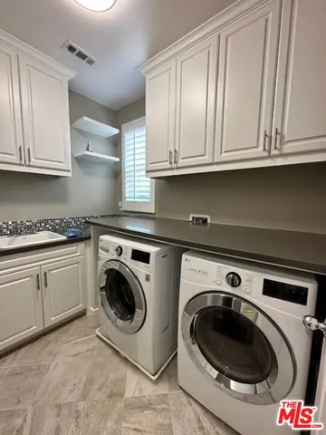 a utility room with sink dryer and washer