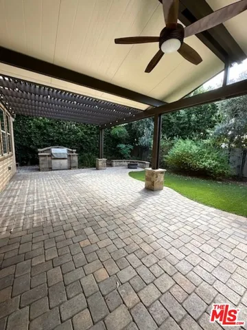 a view of a patio with a table and chairs under an umbrella