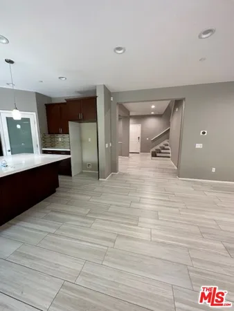 a large room with a bed and a view of kitchen