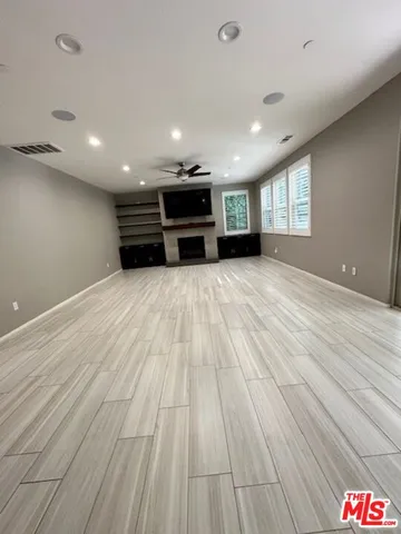 a view of empty room with windows and ceiling fan