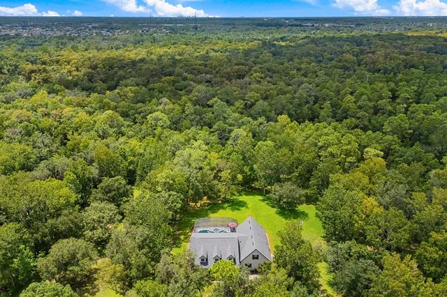 an aerial view of a house with a yard and lake view