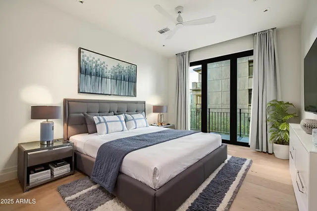 a bedroom with a large bed and a chandelier