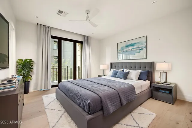 a bedroom with a large bed and a potted plant