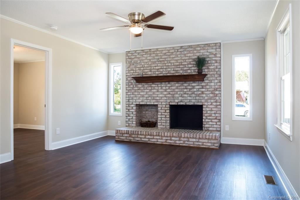 839 Sikes Mill Road Monroe, NC 28110 - Photo 8 of 26 a living room with wooden floors and a fireplace