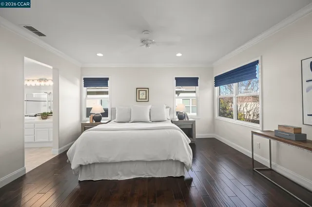 a spacious bedroom with a bed and wooden floor