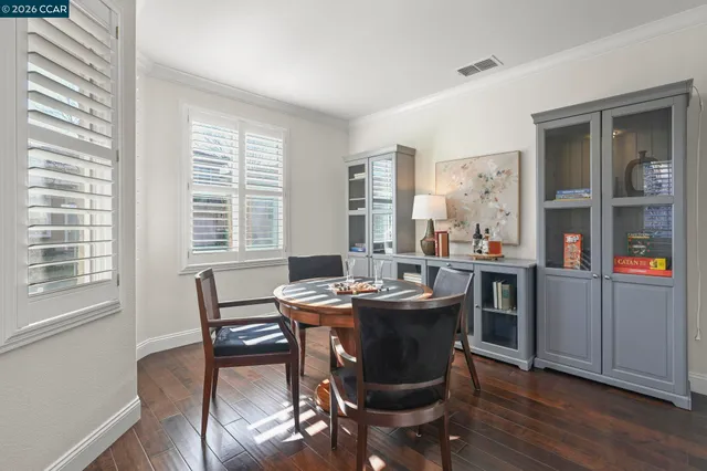 a dining room with furniture window and wooden floor