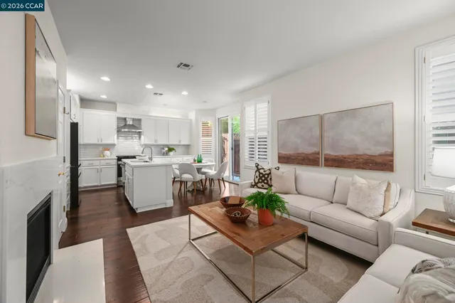 a living room with furniture and a dining table with kitchen view