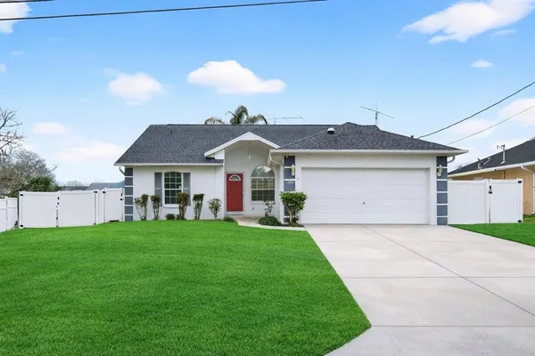 a front view of a house with a garden and yard