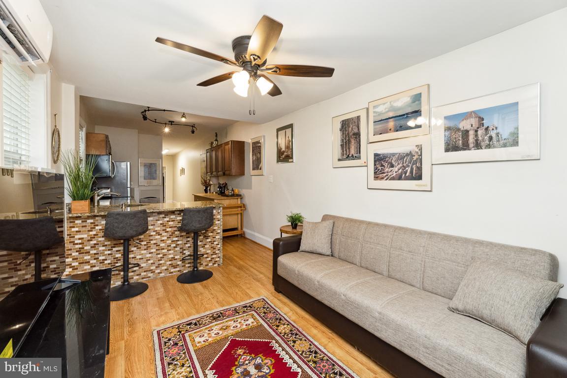 a living room with furniture and a view of kitchen