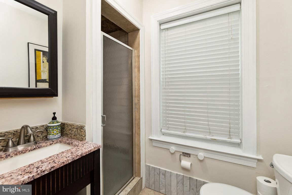 428 8th Street Southeast, Unit A Washington, DC 20003 - Photo 11 of 23 a bathroom with a granite countertop sink toilet a mirror and shower