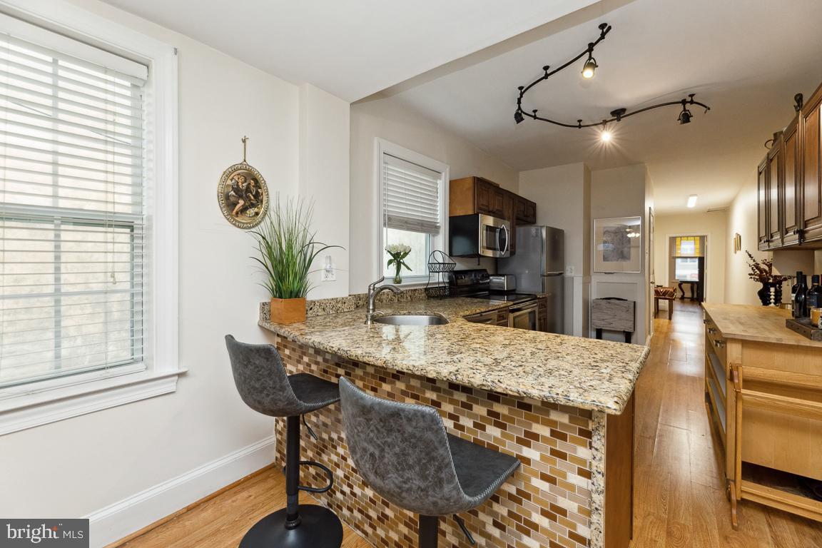 428 8th Street Southeast, Unit A Washington, DC 20003 - Photo 18 of 23 a view of kitchen island dining table wooden floor and living room