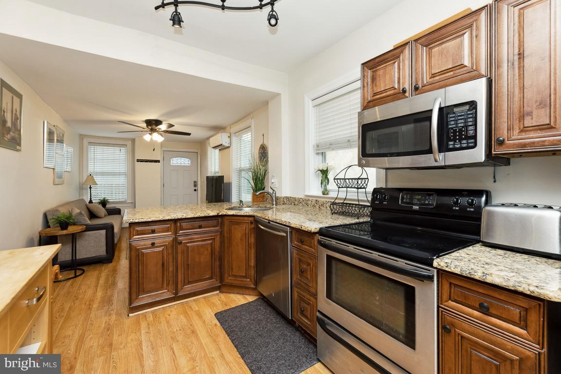 428 8th Street Southeast, Unit A Washington, DC 20003 - Photo 5 of 23 a kitchen with stainless steel appliances granite countertop a stove a sink and a microwave