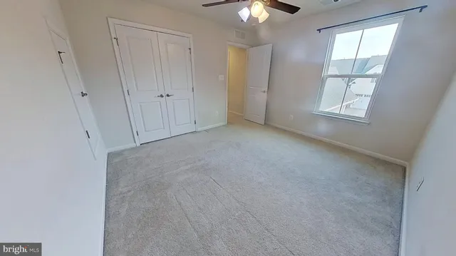 an empty room with chandelier fan