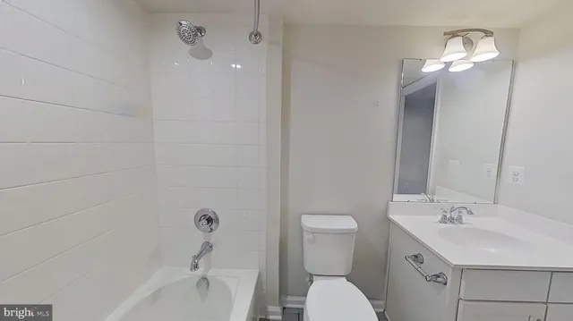 a bathroom with a toilet a sink a tub and mirror