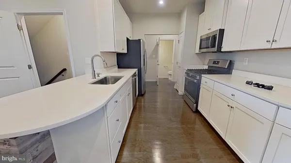 a kitchen with a sink a refrigerator and cabinets