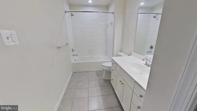 a bathroom with a double vanity sink a toilet and shower