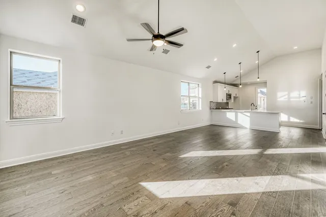a view of a room with a kitchen and windows