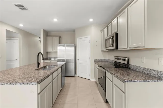 a kitchen with granite countertop kitchen island stainless steel appliances granite countertop a stove and a sink
