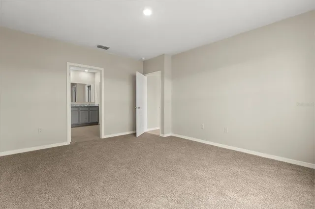 a view of an empty room with closet and window