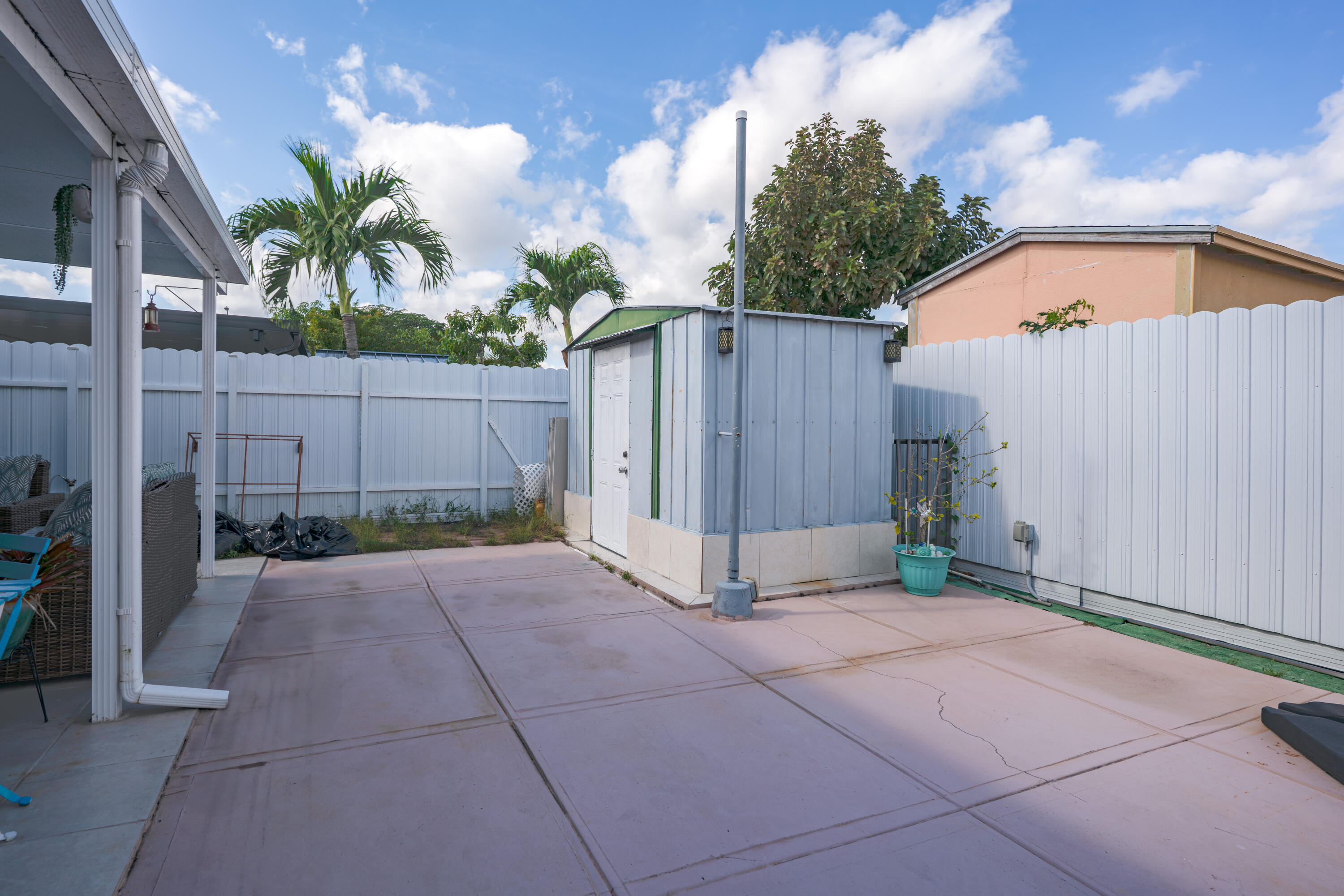 13257 Southwest 277th Terrace Homestead, FL 33032 - Photo 24 of 24 a backyard of a house with potted plants and wooden fence