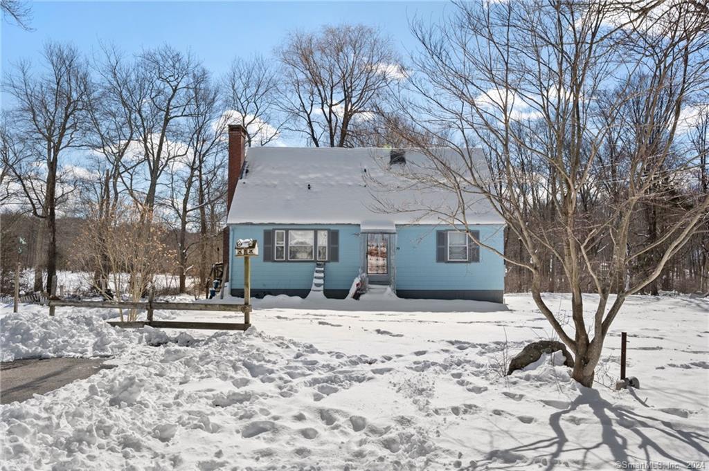 a front view of a house with a yard covered in snow