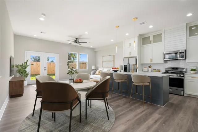 a large dining space with stainless steel appliances granite countertop a stove a sink a dining table and chairs