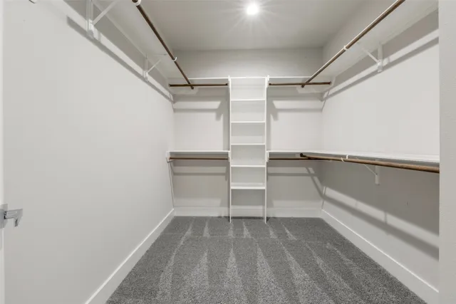 a view of walk in closet with empty racks