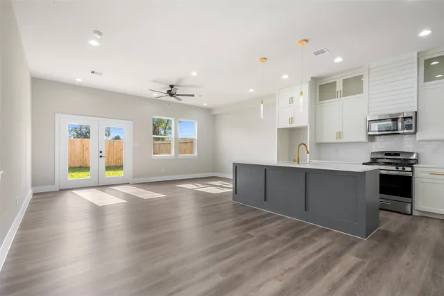 a kitchen with granite countertop a stove a sink and a refrigerator