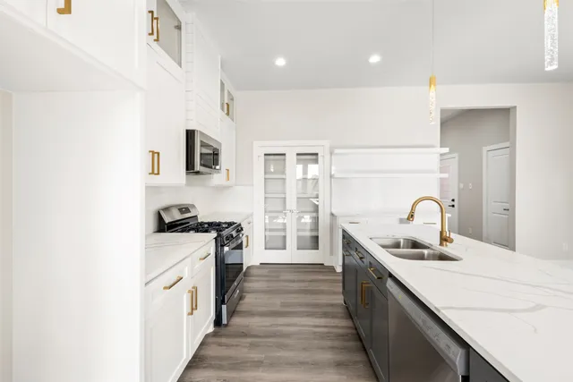 a kitchen with kitchen island granite countertop a stove and a sink