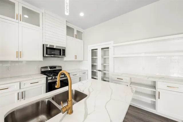 a kitchen with a sink a stove and cabinets