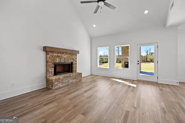 an empty room with windows and fireplace