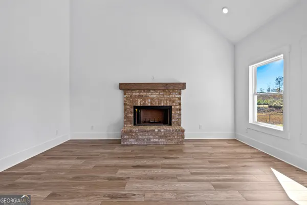 a view of an empty room with window and fire place