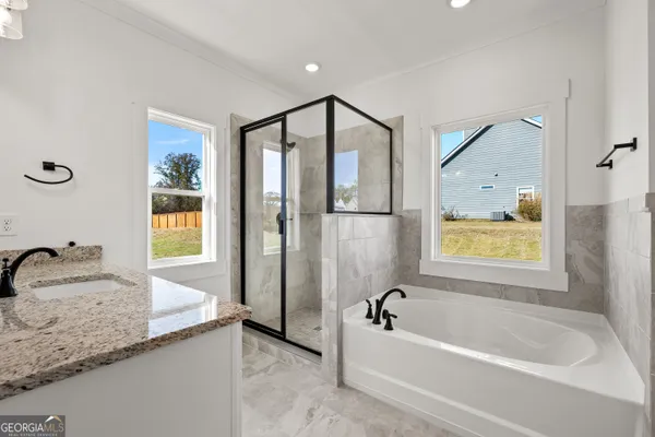 a bathroom with a granite countertop tub sink and mirror