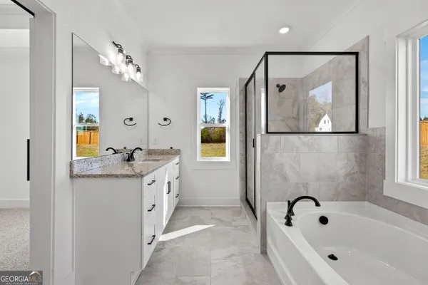 a bathroom with a granite countertop sink mirror and a bathtub