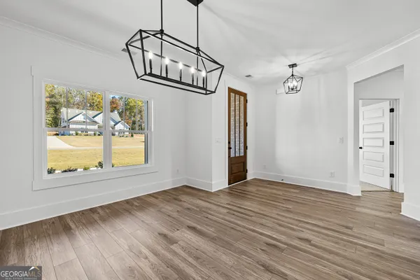 an empty room with wooden floor cabinet and windows
