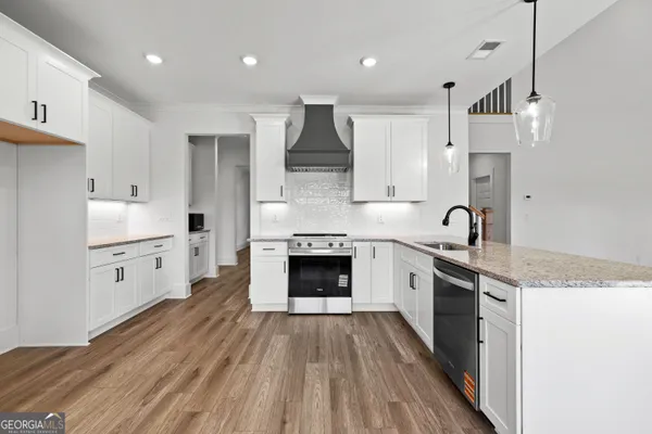 a kitchen with stainless steel appliances granite countertop a stove sink and cabinets